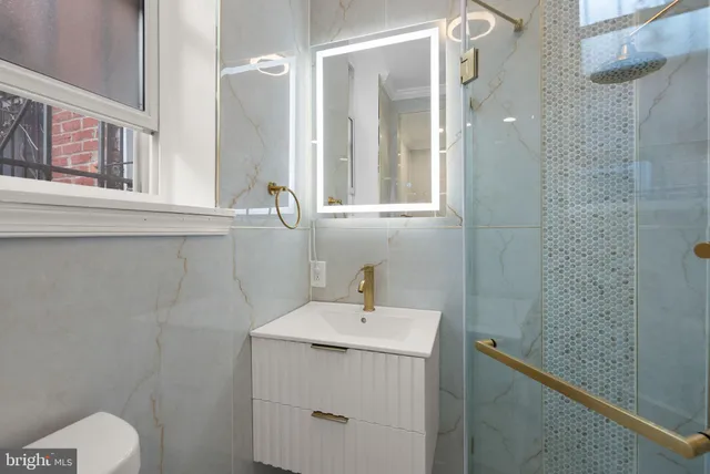 a bathroom with a shower a sink and mirror