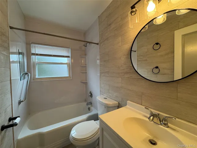 a bathroom with a sink mirror toilet and bathtub