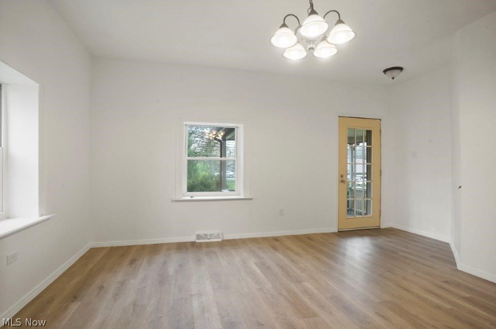 4325 Mayfair Road Uniontown, OH 44685 - Photo 5 of 35 Unfurnished room with a chandelier and light hardwood / wood-style flooring