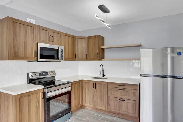 a kitchen with a sink and a stove top oven with wooden floor