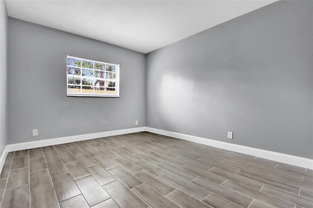 260 Northwest 19th Street, Unit 1 Boca Raton, FL 33432 - Photo 12 of 14 a view of an empty room with wooden floor and a window