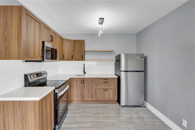 a kitchen with a refrigerator a stove top oven a sink and dishwasher