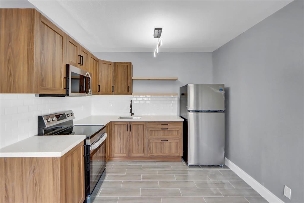 260 Northwest 19th Street, Unit 1 Boca Raton, FL 33432 - Photo 2 of 14 a kitchen with a refrigerator a stove top oven a sink and dishwasher
