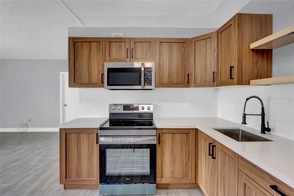 260 Northwest 19th Street, Unit 1 Boca Raton, FL 33432 - Photo 3 of 14 a kitchen with a stove and a sink