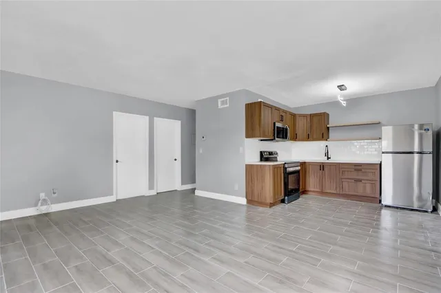 a view of kitchen with stainless steel appliances cabinets and wooden floor