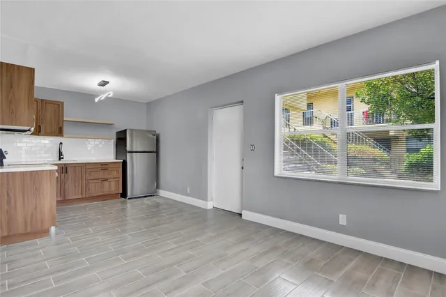 a view of kitchen with stainless steel appliances a refrigerator sink and microwave