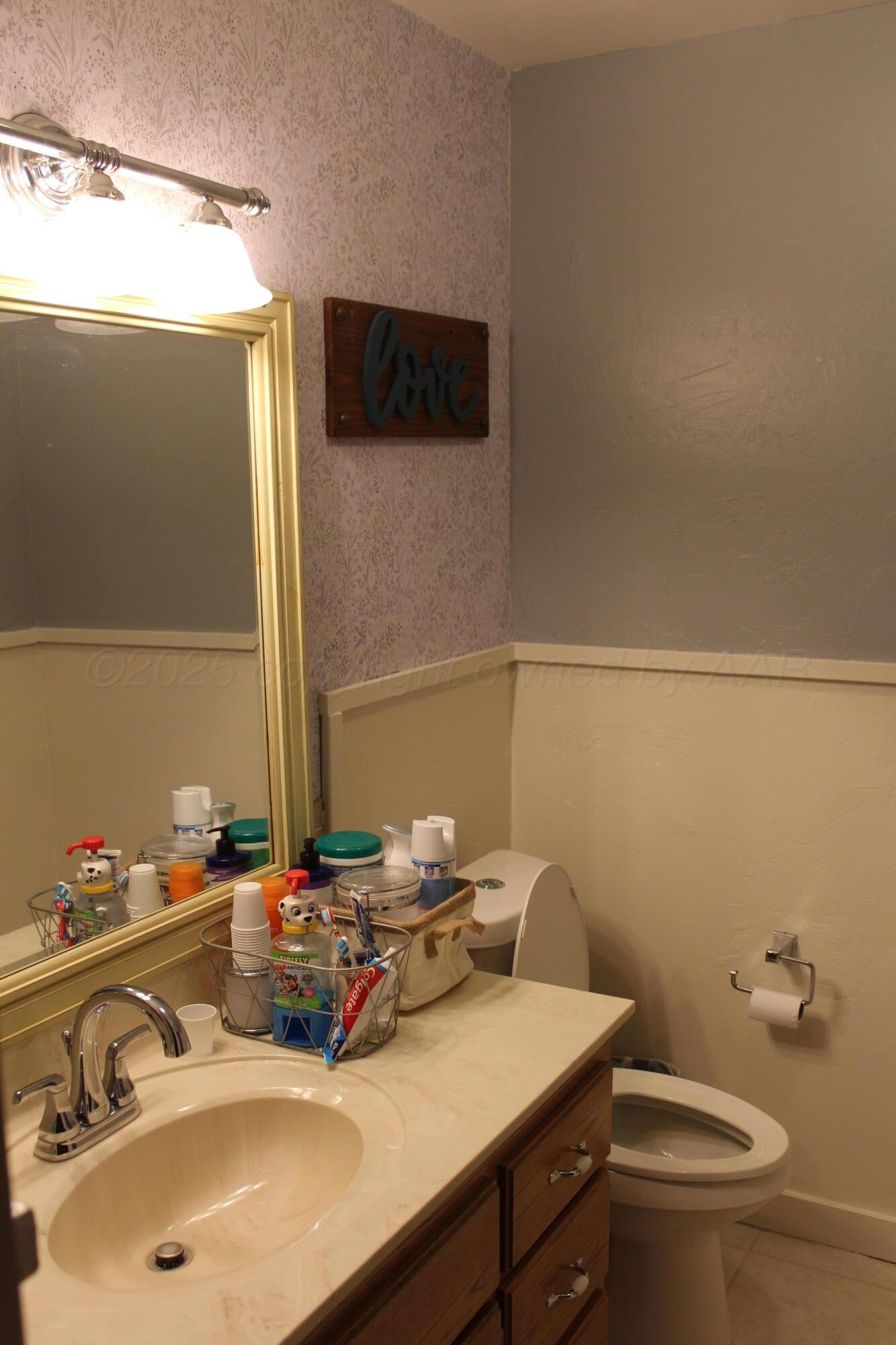 622 North 14th Street Memphis, TX 79245 - Photo 9 of 29 a bathroom with a sink a toilet and mirror