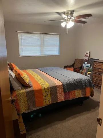 a bed sitting in a bedroom next to a lamp