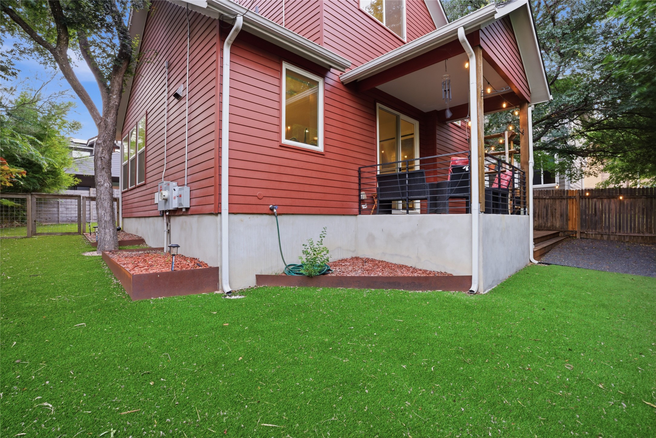 1709 Perez Street, Unit 2 Austin, TX 78721 - Photo 32 of 33 A vibrant exterior features an inviting patio area and a fenced backyard with lush artificial turf.