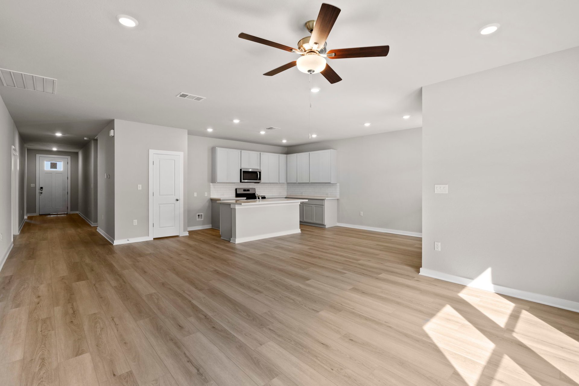 13621 Gray Landing Drive Elgin, TX 78621 - Photo 15 of 36 a view of an empty room with kitchen appliances and a ceiling fan