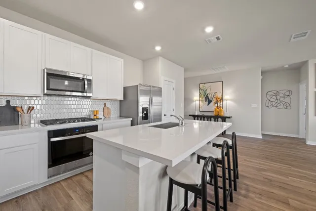 a kitchen with stainless steel appliances a refrigerator stove and microwave