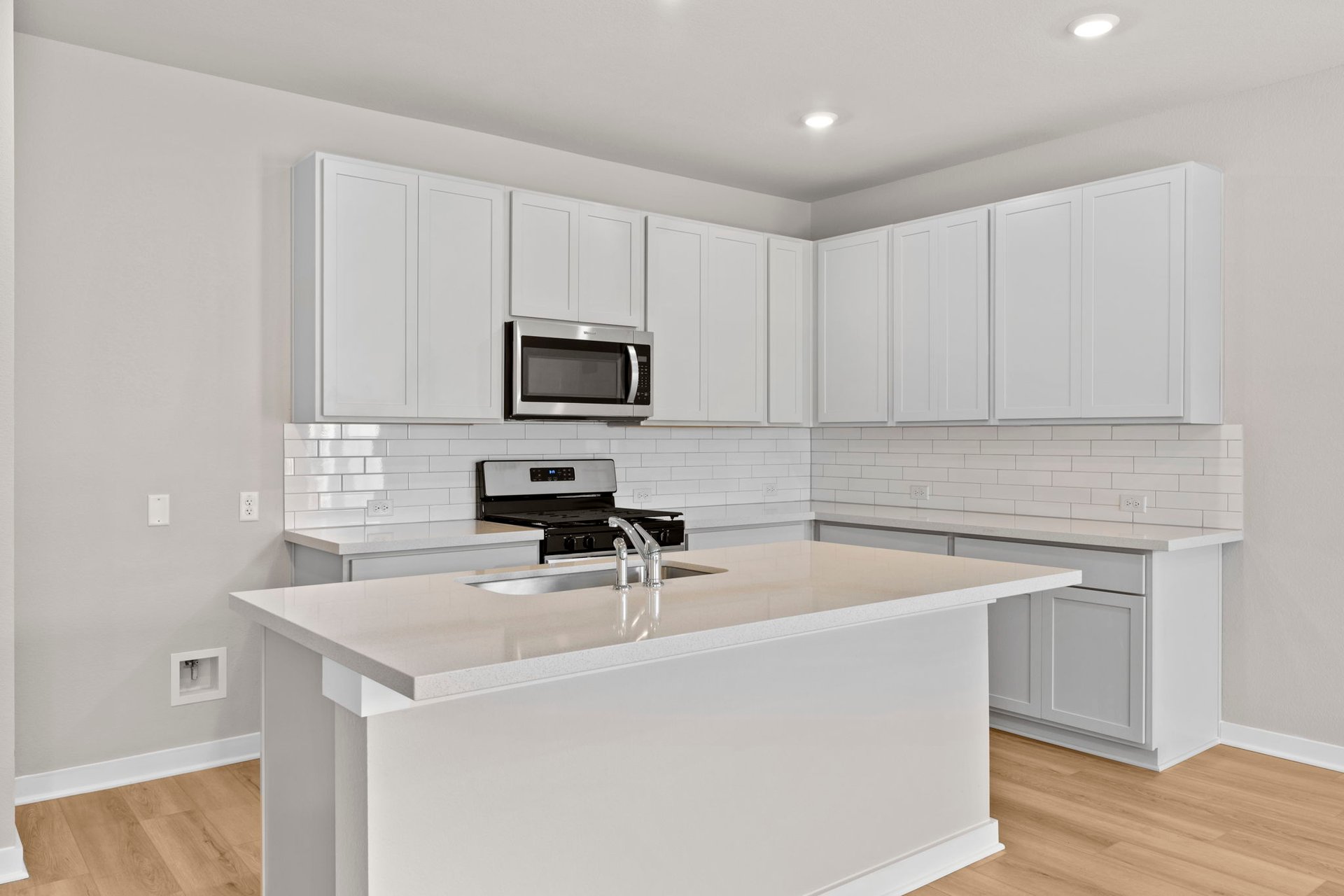 13621 Gray Landing Drive Elgin, TX 78621 - Photo 9 of 36 a kitchen with a sink a stove a microwave and wooden cabinets