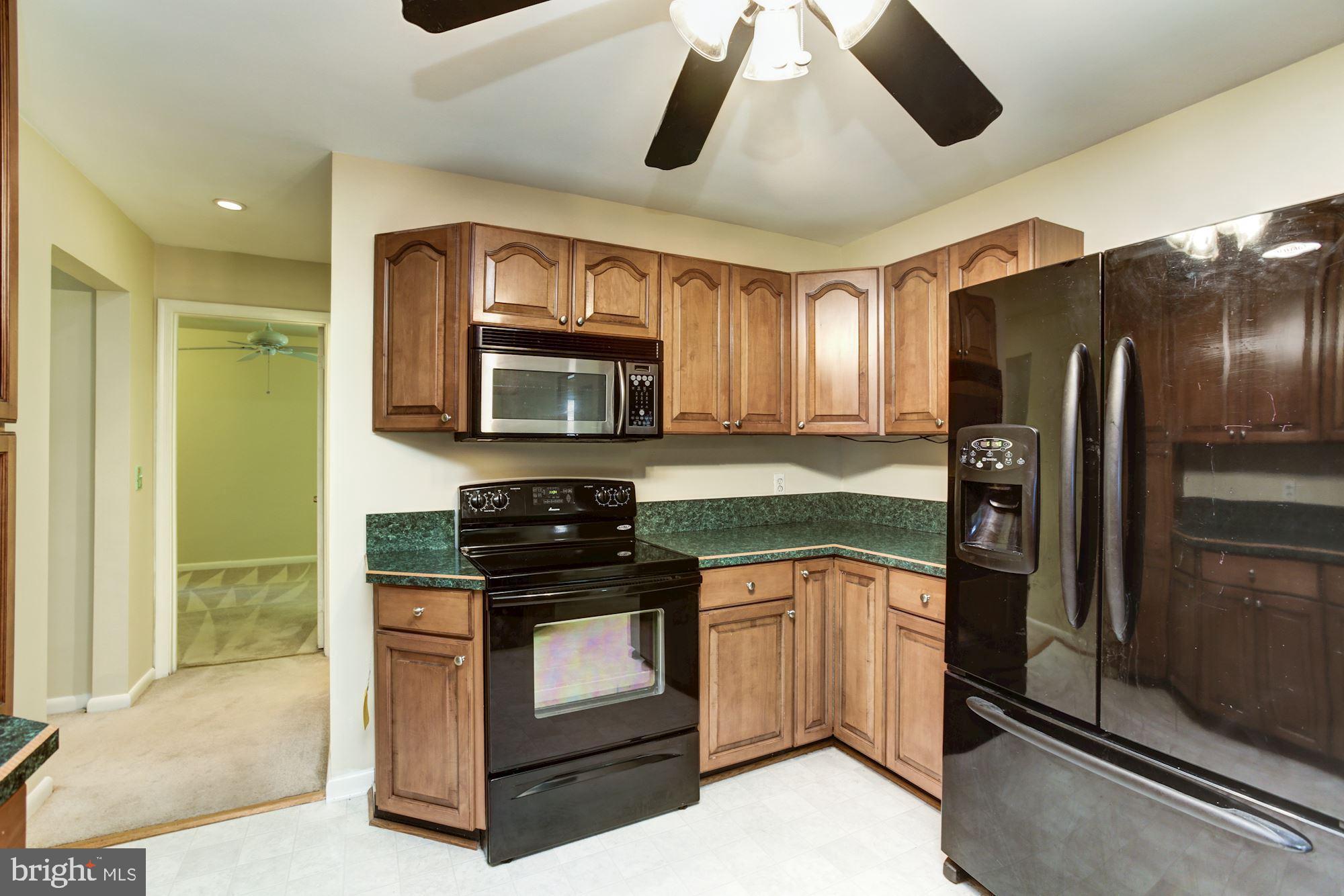 2800 Ridge Road Windsor Mill, MD 21244 - Photo 10 of 37 a kitchen with stainless steel appliances granite countertop a refrigerator a stove a sink and a microwave