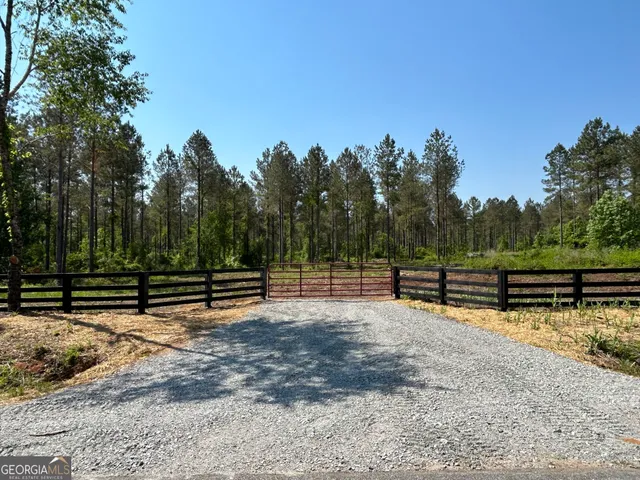 a view of a yard with wooden fence