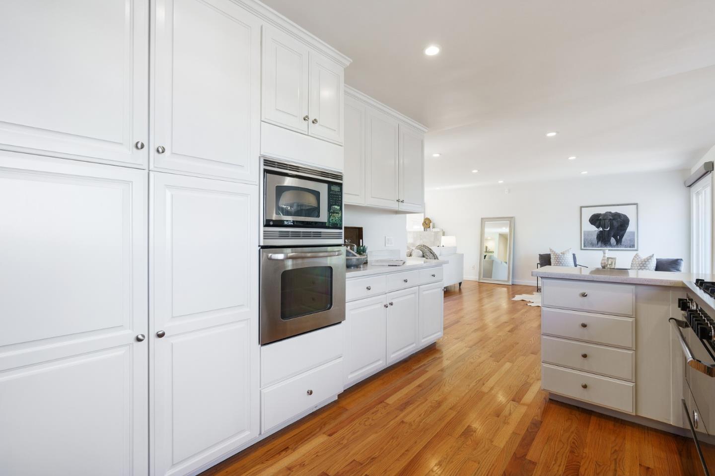 1150 Elmwood Drive Millbrae, CA 94030 - Photo 19 of 46 a kitchen with white cabinets and stainless steel appliances