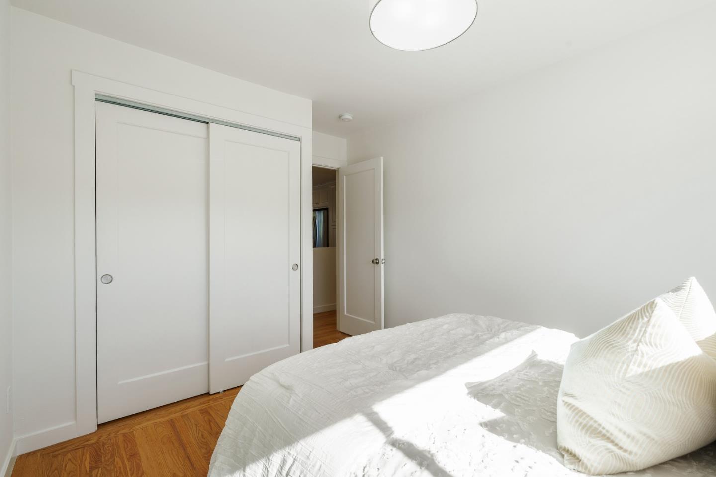 1150 Elmwood Drive Millbrae, CA 94030 - Photo 22 of 46 a bedroom with a bed and a lamp