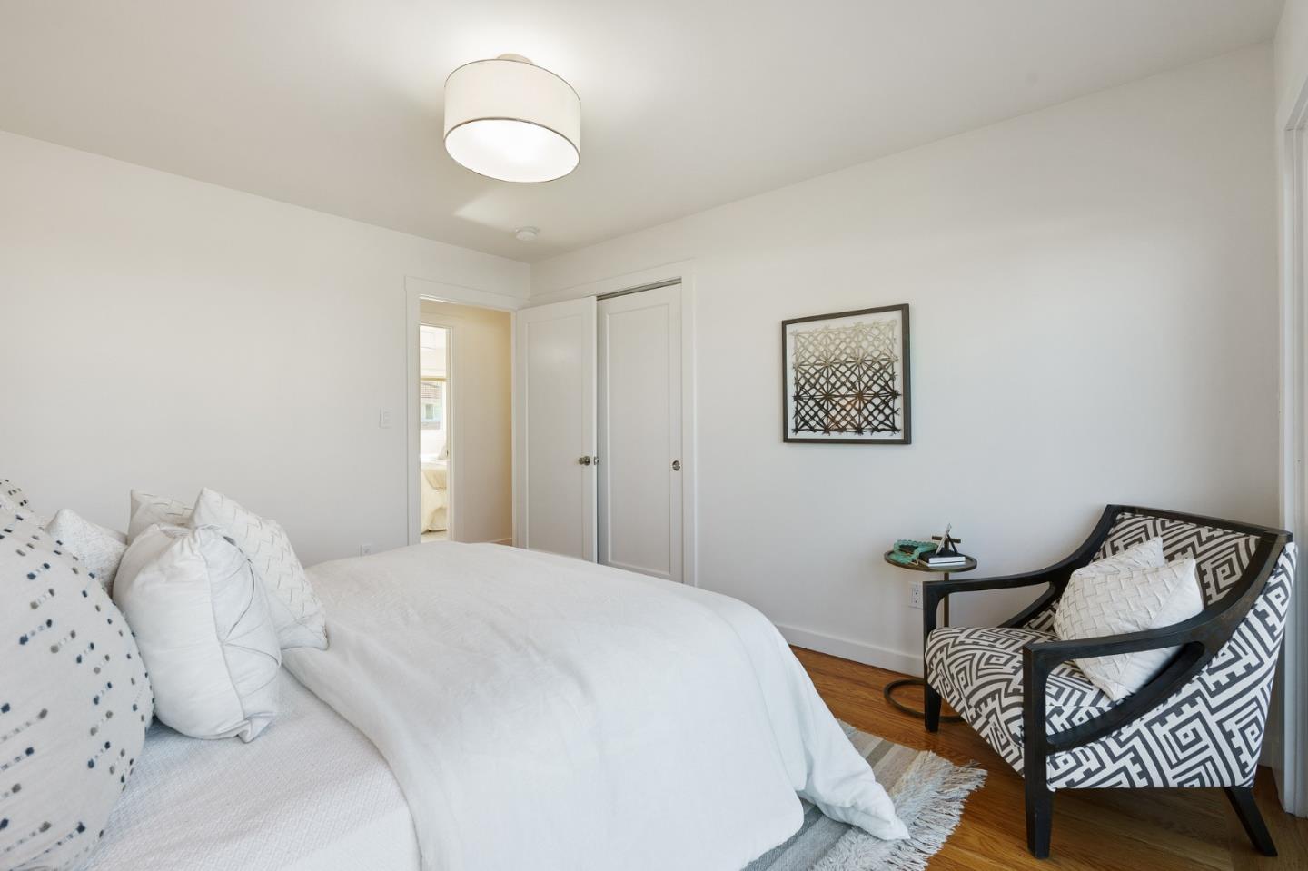 1150 Elmwood Drive Millbrae, CA 94030 - Photo 30 of 46 a bedroom with a bed and wooden floor