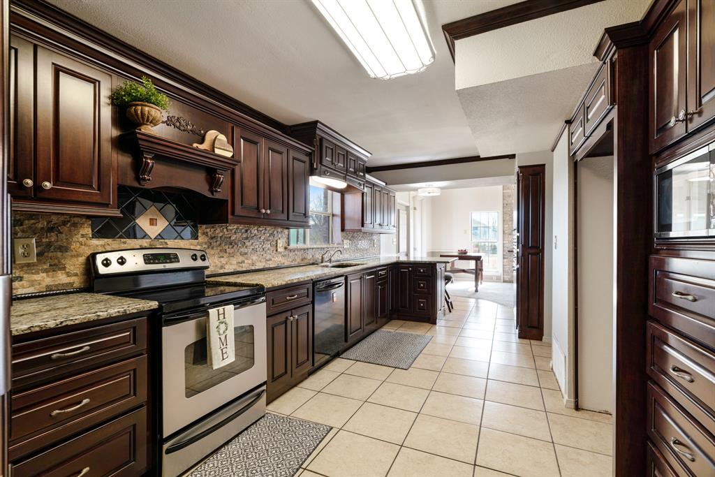 374 County Road Paris, TX 75462 - Photo 11 of 38 a kitchen with stainless steel appliances granite countertop a stove a sink and a microwave