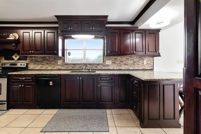 a kitchen with stainless steel appliances granite countertop a stove a sink and a microwave