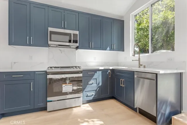 a kitchen with granite countertop a stove microwave and sink