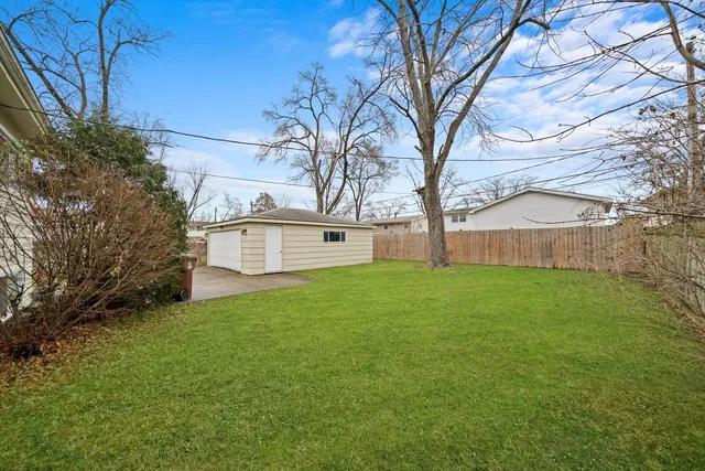 a view of a house with backyard and trees