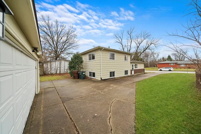 a view of a white house with a big yard