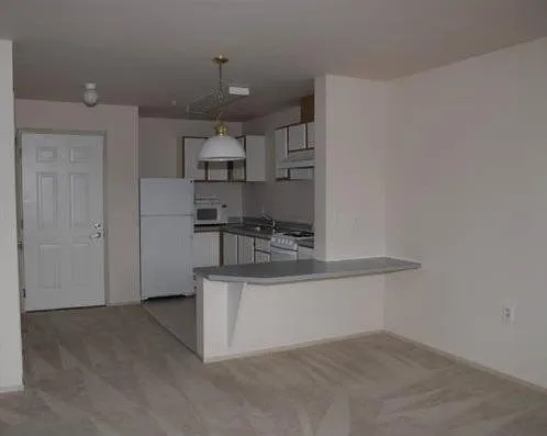 a view of a kitchen with refrigerator and cabinets