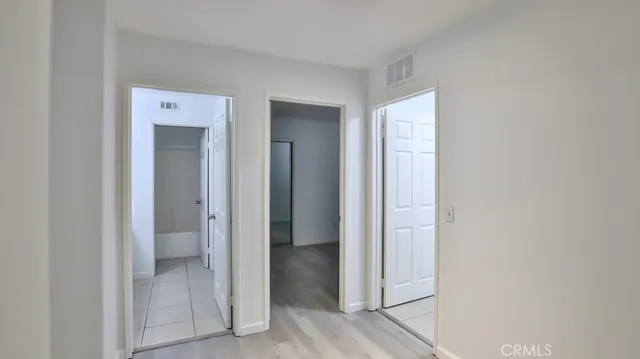a view of an empty room with closet and a window
