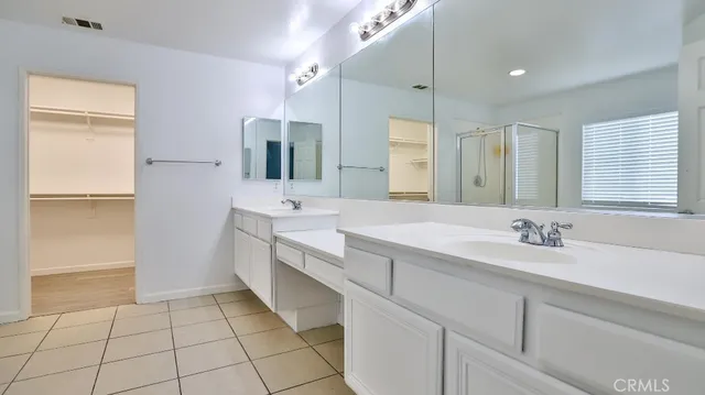 a bathroom with a double vanity sink a mirror and a shower
