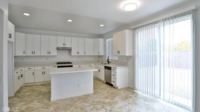 a kitchen with a stove sink and cabinets