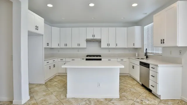 a kitchen with white cabinets and white appliances