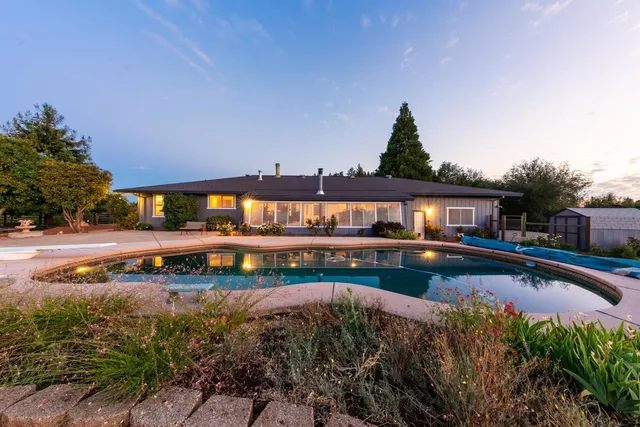 a view of swimming pool with outdoor seating and yard in the back