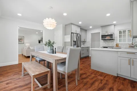 a dining room with furniture a chandelier and wooden floor