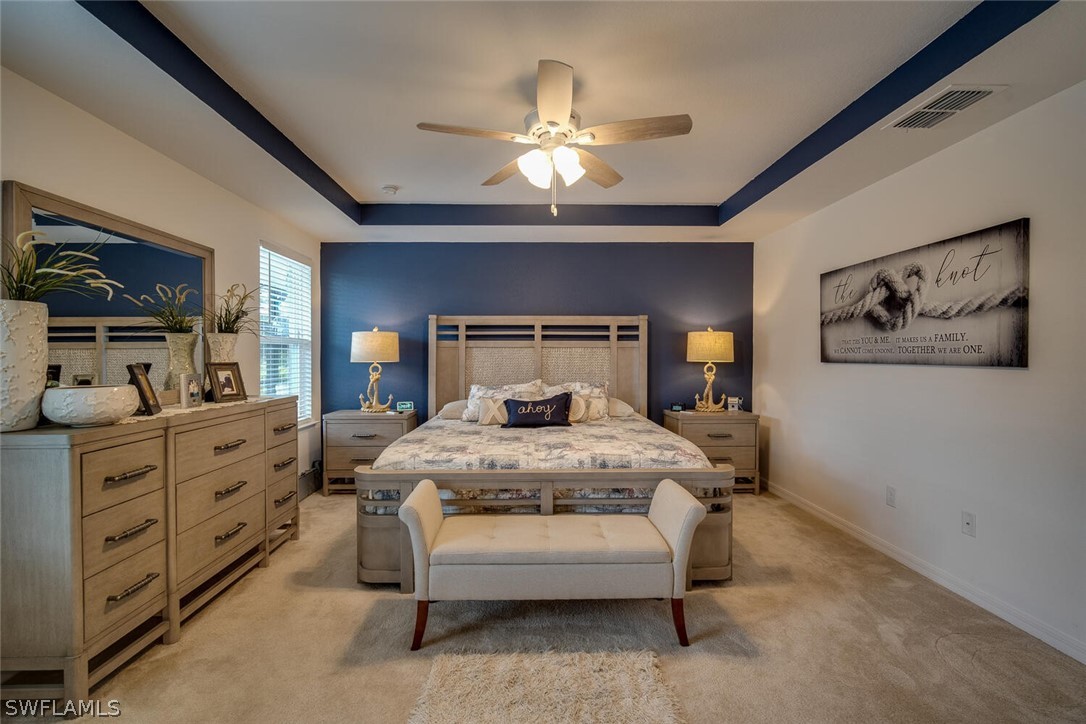 1212 Oceanic Road Punta Gorda, FL 33983 - Photo 15 of 29 a bedroom with a bed a chandelier and a painting on the wall