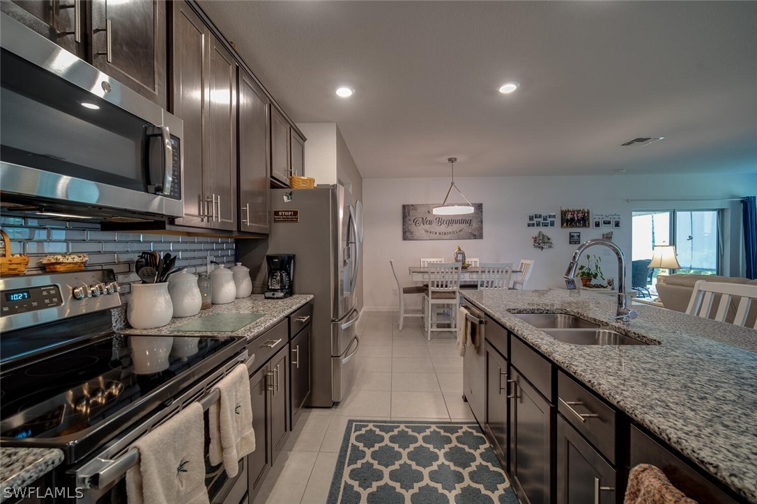 1212 Oceanic Road Punta Gorda, FL 33983 - Photo 8 of 29 a kitchen with stainless steel appliances granite countertop a sink stove and refrigerator