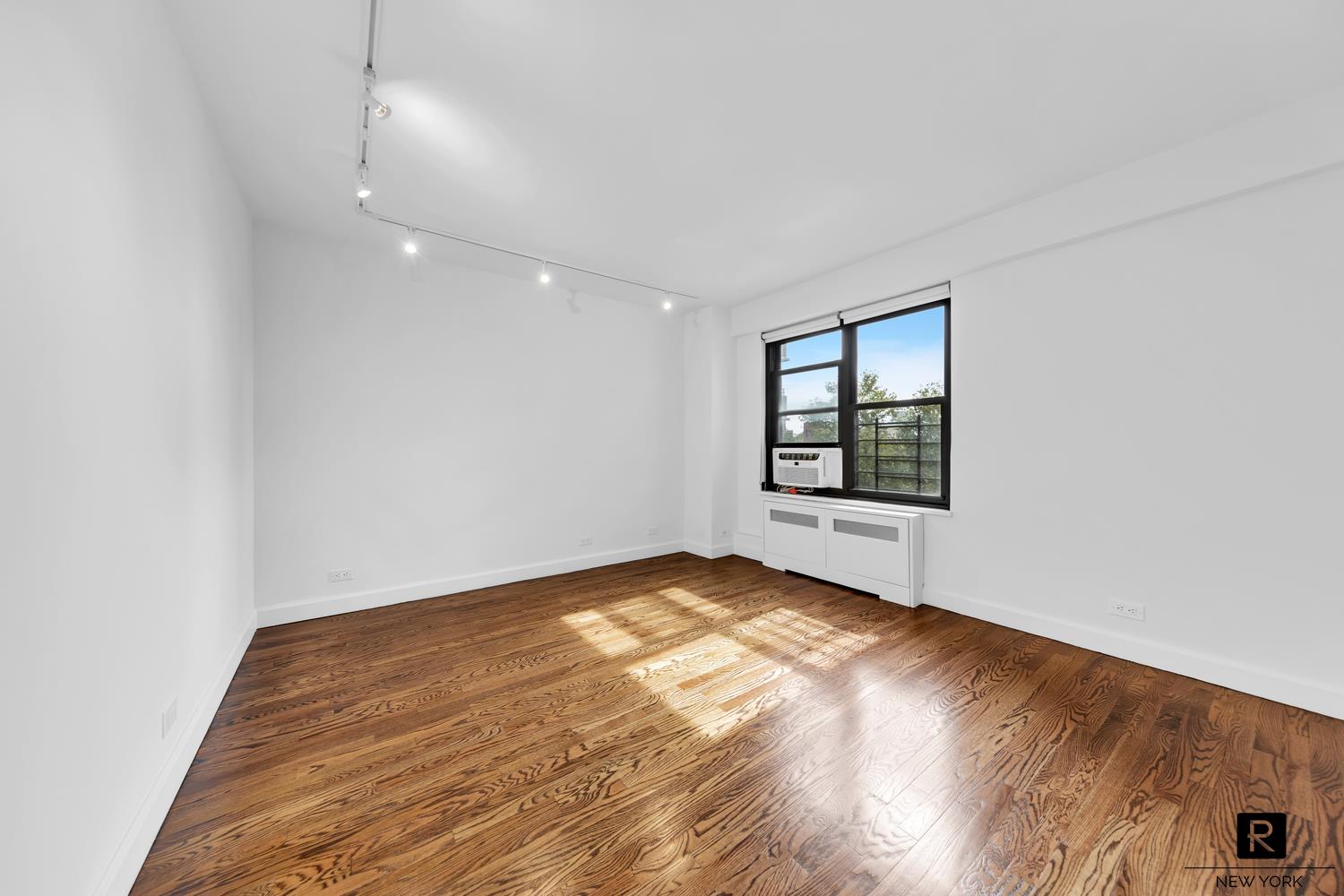 264 East Broadway, Unit C405 Manhattan, NY 10002 - Photo 10 of 12 an empty room with windows