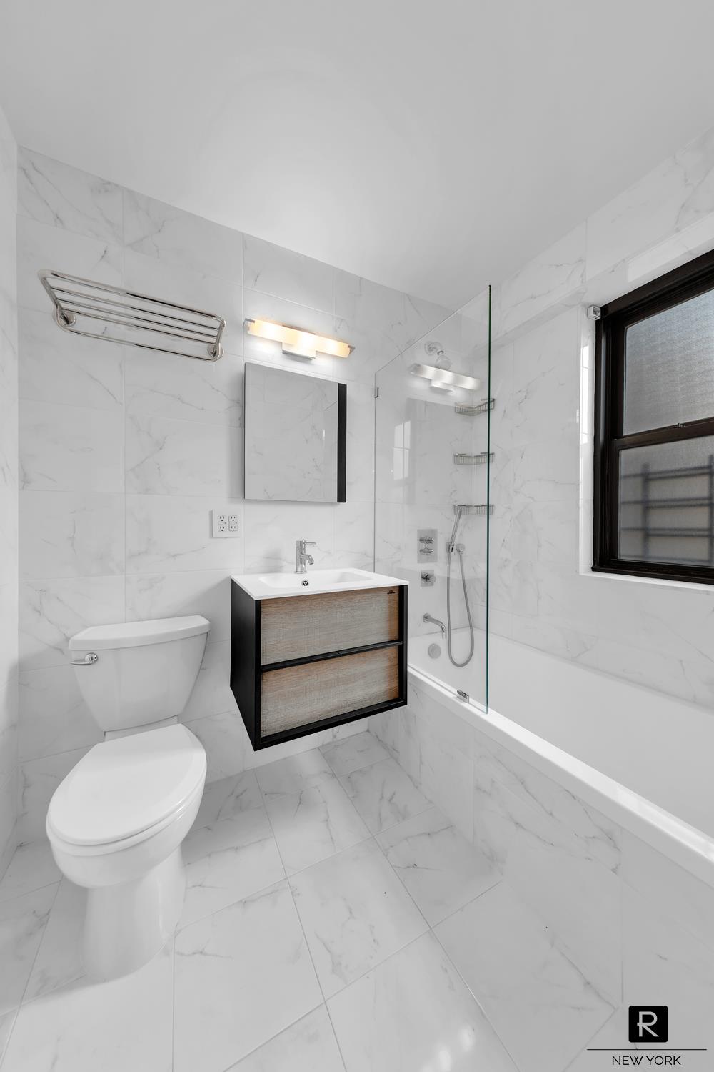 264 East Broadway, Unit C405 Manhattan, NY 10002 - Photo 11 of 12 a bathroom with a toilet sink and mirror