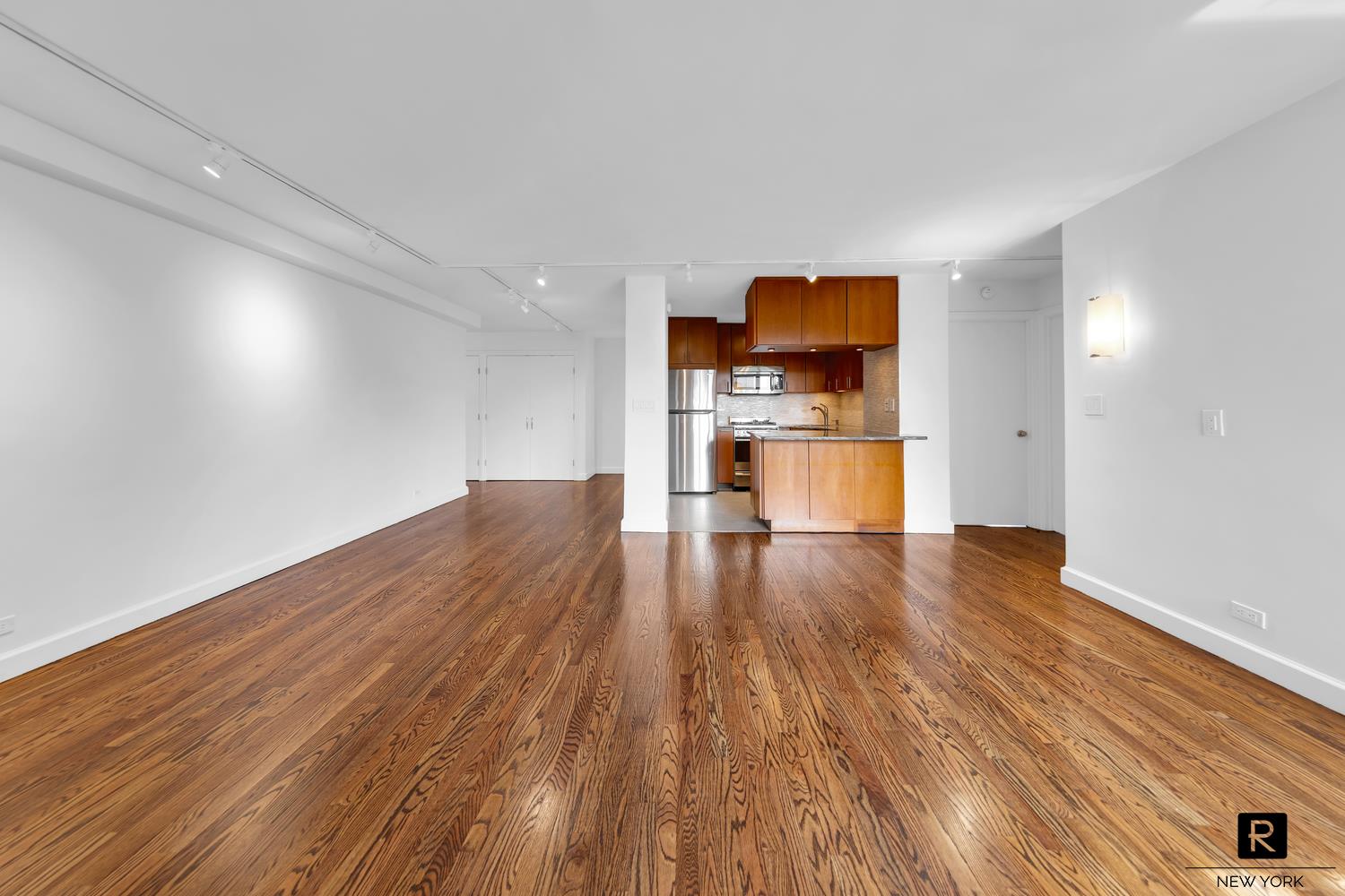 264 East Broadway, Unit C405 Manhattan, NY 10002 - Photo 7 of 12 a view of empty room with wooden floor and a window