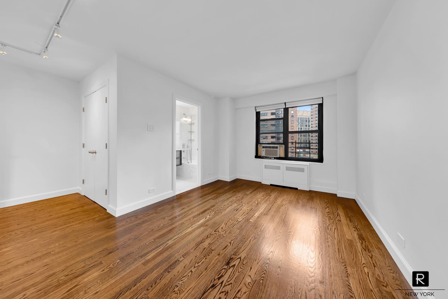 264 East Broadway, Unit C405 Manhattan, NY 10002 - Photo 8 of 12 wooden floor in an empty room with a window