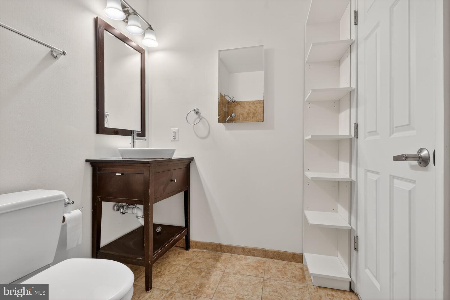 2627 Adams Mill Road Northwest, Unit 104 Washington, DC 20009 - Photo 11 of 16 a bathroom with a toilet a sink and mirror