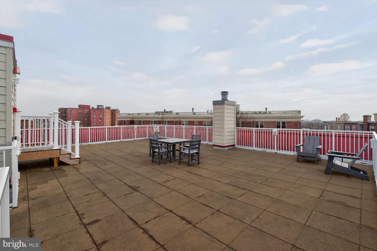2627 Adams Mill Road Northwest, Unit 104 Washington, DC 20009 - Photo 16 of 16 a view of roof deck with table and chairs and wooden fence