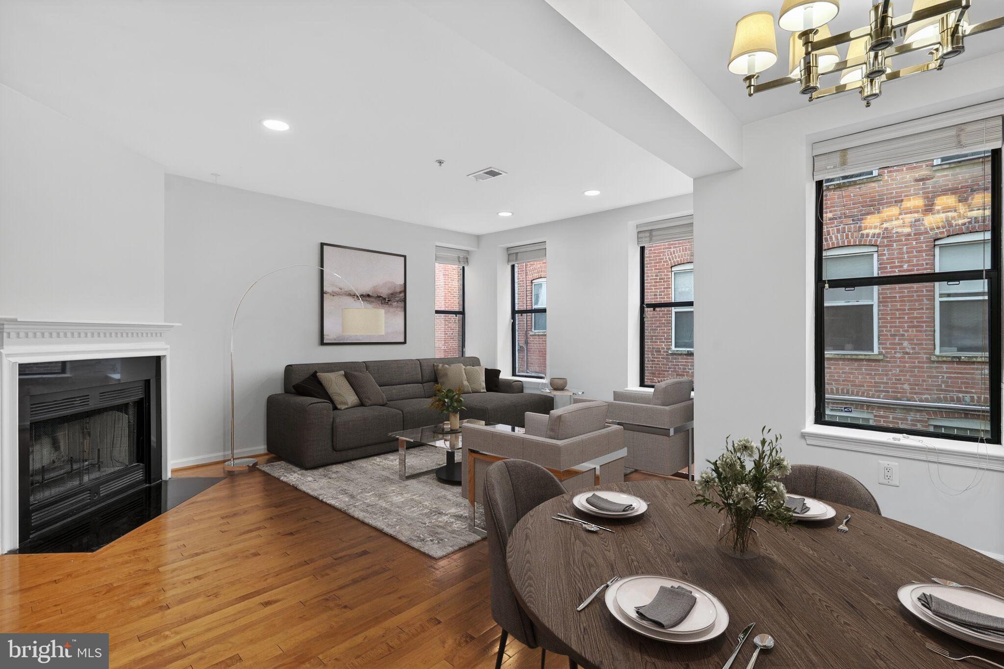 2627 Adams Mill Road Northwest, Unit 104 Washington, DC 20009 - Photo 3 of 16 a living room with furniture a fireplace and a chandelier