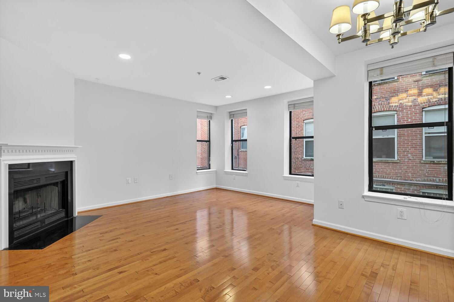2627 Adams Mill Road Northwest, Unit 104 Washington, DC 20009 - Photo 8 of 16 a view of an empty room with a window and fireplace