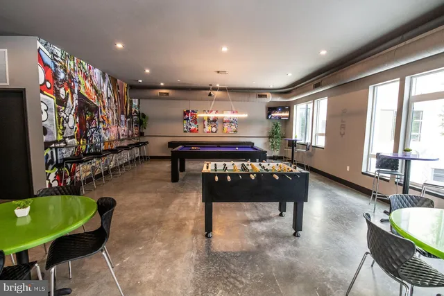 a room with furniture pool table and wall paintings