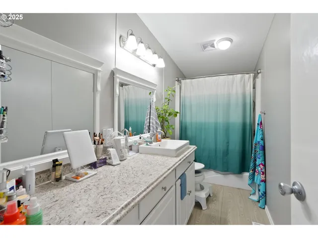 a bathroom with a sink mirror and a toilet