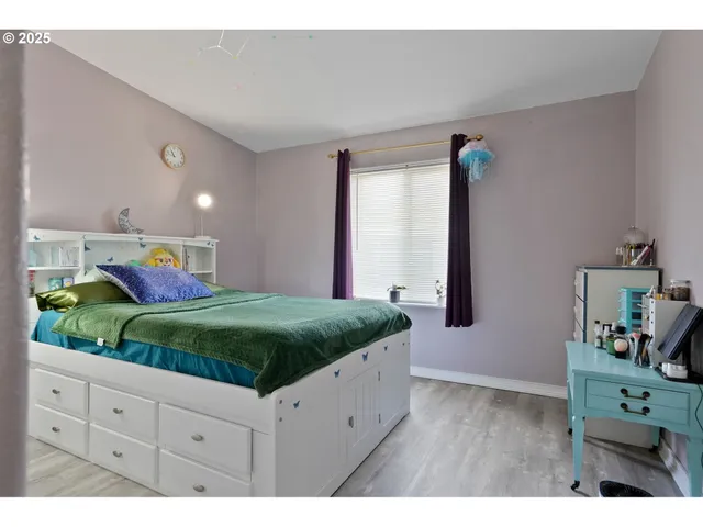 a spacious bedroom with a bed and a dresser