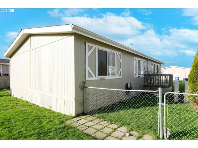 a view of a small house with wooden fence