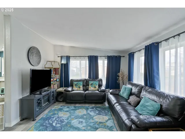 a living room with furniture a flat screen tv and a window