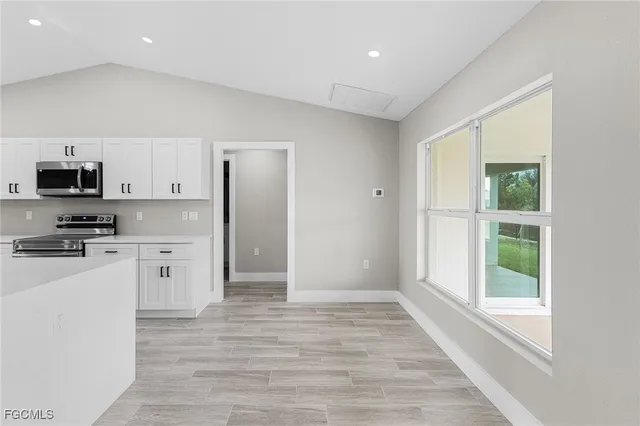 a kitchen with granite countertop a refrigerator and a stove top oven