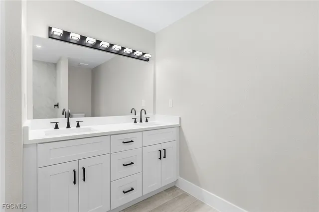 a bathroom with a double vanity sink and mirror